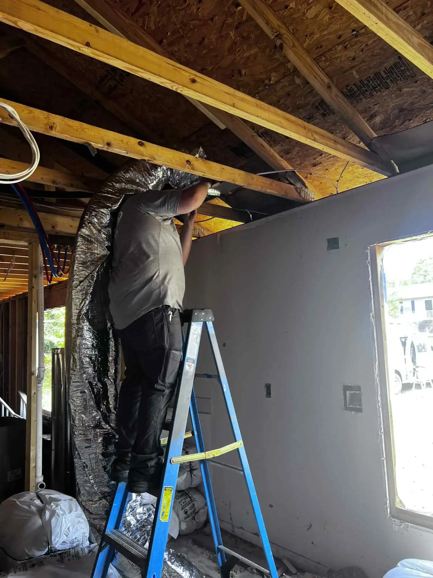 Dependable HVAC technician working on ductwork in Troy